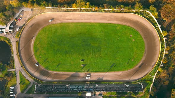 Aerial View on Top Races on the Racetrack. Cars Driving in a Circle Drifting Around Corners Compete