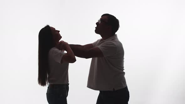 Silhouette of Man From Rage and Anger Strangling Woman White Background in Studio Side View