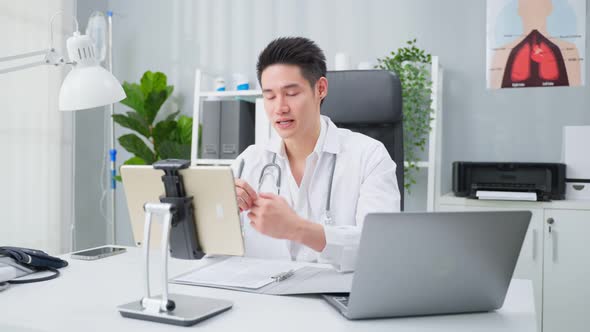 Asian male medical doctor talking virtual online with patient at home.