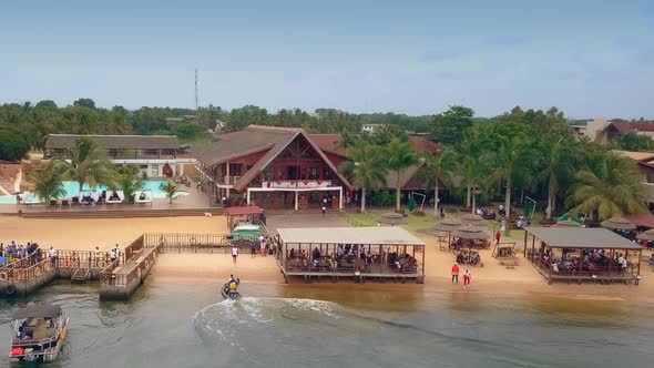 Cinematic reverse drone shot of Aqua Safari Resort beach front with boats