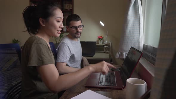 Multiethnic couple in love watching movie on laptop