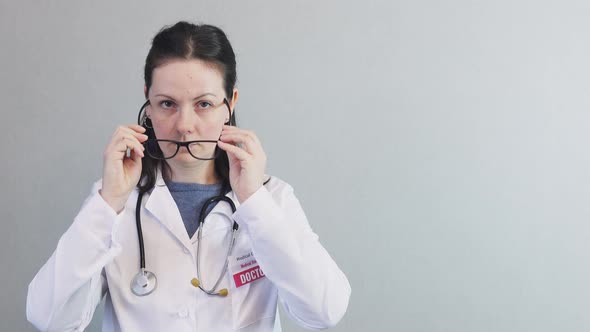 Portrait Brunette Female Doctor White Uniform Stethoscope Taking Off Glasses
