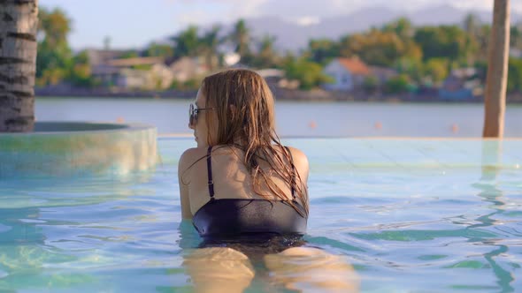A Young Woman Relaxes in a Tropical Resort with Hot Springs, Waterfalls and Swimming Pools with Hot