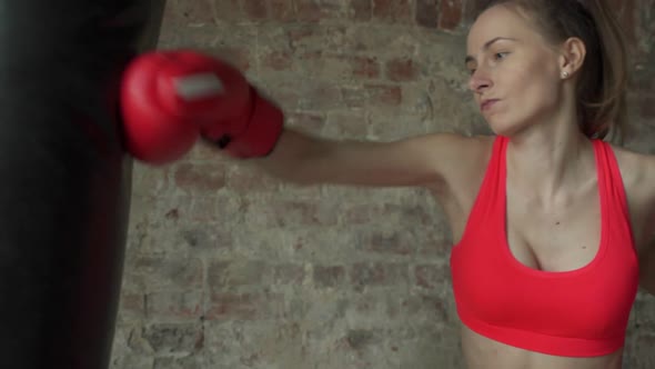 Boxer Young Female Beats Pear in a Modern Gym