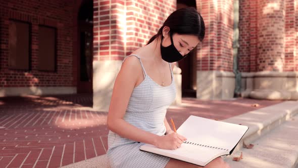Asian female college student working on her homework 