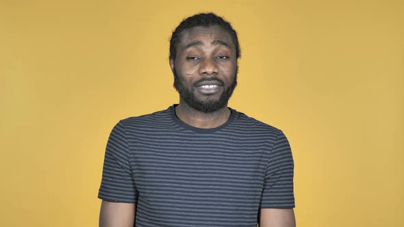 Casual African Man Shaking Head to Reject Isolated on Yellow Background