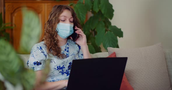 Businesswoman Talking on Mobile Phone While Doing Online Computer Work on Laptop