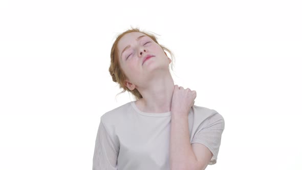 Portrait of Attractive Redhaired Woman in White Shirt Massaging Her Painful Neck Stretching Turning