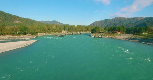 Low Altitude Flight Over Fresh Fast Mountain River with Rocks at Sunny Summer Morning.