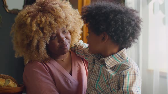 Mother Talking to Little Son at Dinner Table