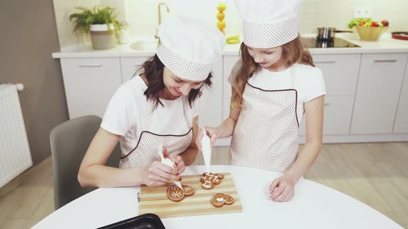 Charming Mother and Cute Daughter Glazing Ginger Cookies