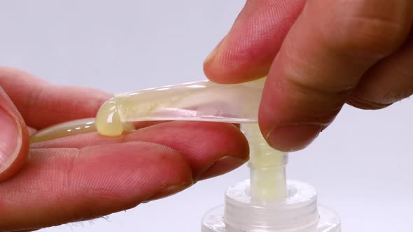 Man hands using soap dispenser, macro shot in 4k. Extreme close up view with white background.