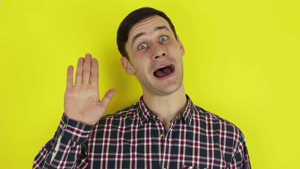 Close Up Portrait of a Young Attractive Guy He is Smiling and Waving Goodbye to His Friends