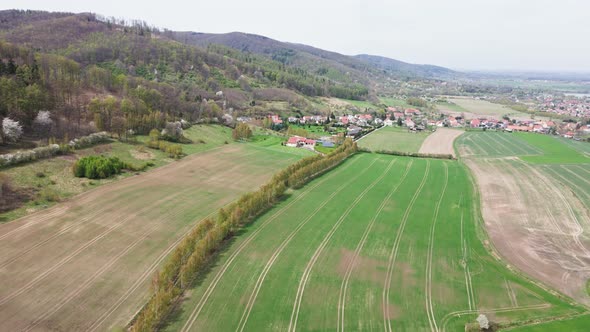 Mountain Village Among Green Fields Aerial View