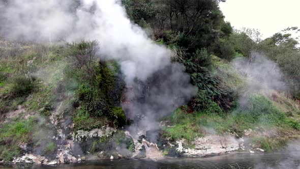 Waimangu Volcanic Rift Valley Cathedral Rock on Frying Pan Crater Lake releasing steam in Rotorua, N