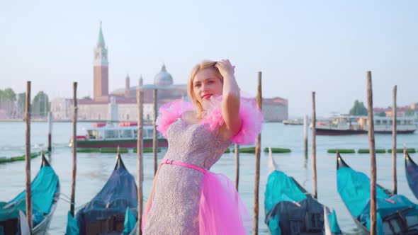 Beautiful Smiling Blonde Girl in Front of the Venetian Gondolas