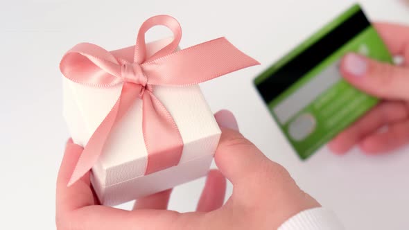 Close Up View of Female Hand Holding Gift Present Box Using Online Banking Application on Smartphone