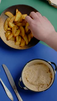 Vertical Tabletop Video Man Scoops Up Cheese Sauce with Crispy Potato Wedges