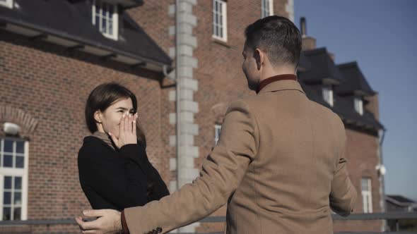 Wealthy Caucasian Man Opening Eyes of Surprised Young Woman Showing New Luxurious House