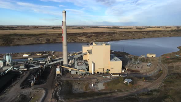 Slow 4k sideways flight over gas and coal powered generating plant in rural Country setting during s