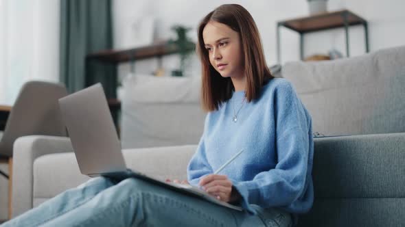 Woman Taking Notes During Video Chat on Laptop