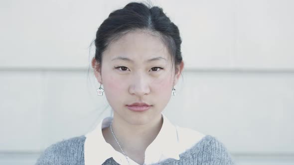 Young Confident Asian Woman Looking Serious at Camera Outdoors