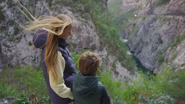 A Woman and Her Son Stand at the Roadside Observing a Magnificent Canyon of the Moracha River