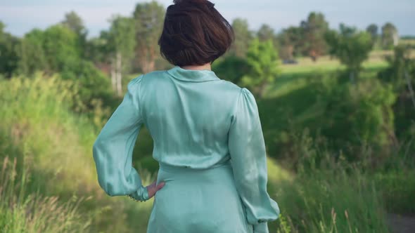 Back View Confident Slim Woman Standing Outdoors Admiring Beauty of Nature on Summer Spring Day