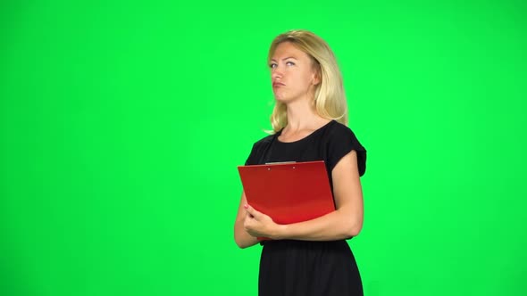 Woman with a Red Folder Goes Carefully Looking Around and Taking Notes, Chroma Key. Slow Motion