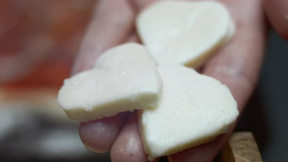 Spreading Heart Shaped Mozzarella Slices Over Pizza Dough