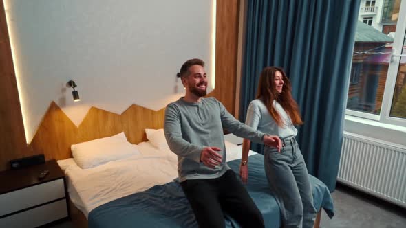 Young couple in hotel room fall on bed