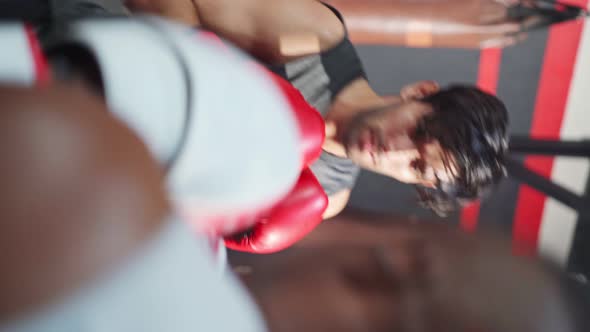 Vertical shot of Active Fitness trainer teach and motivate young Caucasian sportsman doing boxing.