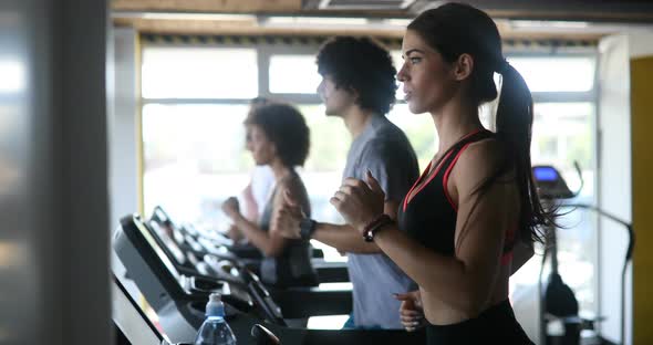 Group of Young People Running on Treadmills in Sport Gym