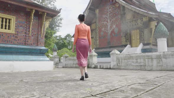 Back Of Asian Girl Wearing Traditional Dress Walk Around Xieng Thong Temple