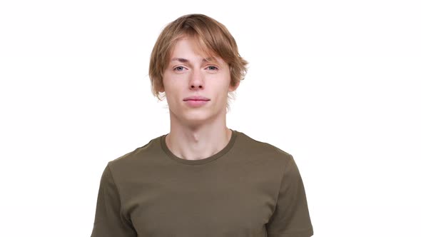 Portrait of Caucasian Guy in Green Tshirt Looking on Camera Being Calm and Glad Being Isolated Over