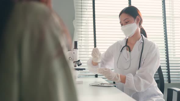 Expert specialist using a rapid antigen test to examiner young female patient in a hospital.