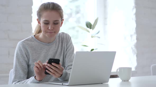 Young Woman Browsing Internet on Smartphone