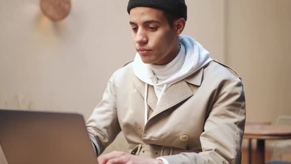 Serious Arabian man working on laptop