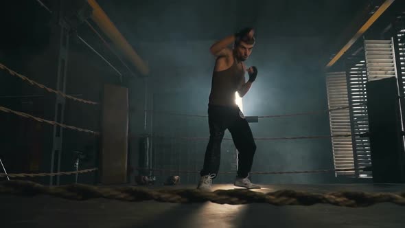 Light-Weight Caucasian Man Boxing On The Ring In Light Rays