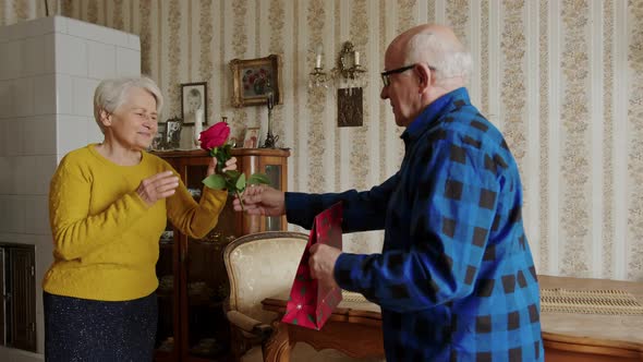 Couple of Elderly Aged Woman and Senior Man Giving a Surprise Gift on Her Special Day Such As