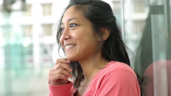 Woman leaning against window, smiling