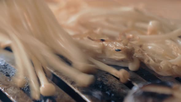 The Cook Prepares Mushrooms on Korean BBQ Gril Plate