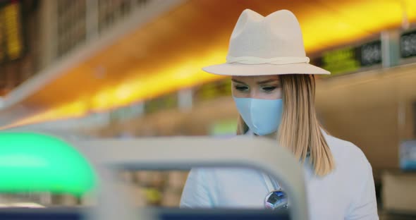 Safe Travels Under COVID-19. Attractive Woman in Face Mask Check-in at Airport