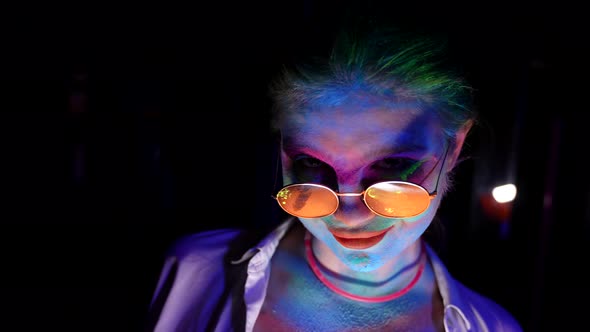 Crazy Lady with Fluorescent Dyes on Face and Hair in Uv Light in Nightclub Horror Movie Concept