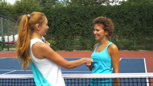 Two Girls Greeting on a Tennis Court