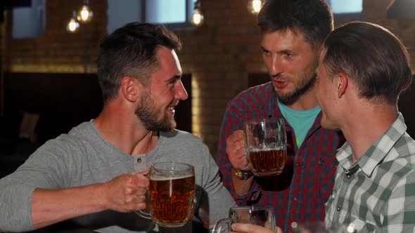 Group of Friends Smiling To the Camera Holding Up Their Beer Glasses at the Bar