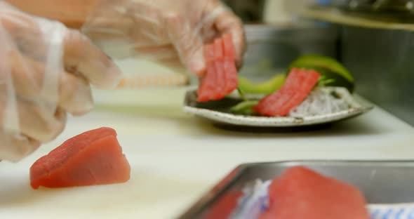 Male chef arranging sushi in a plate at kitchen 4k