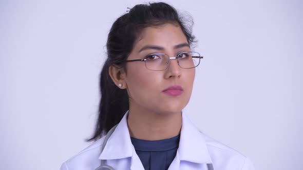 Face of Young Serious Persian Woman Doctor Nodding Head No