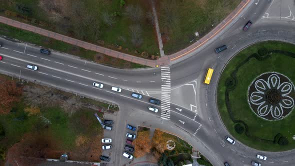 4k aerial view of roundabout road with circular cars in small european city at cloudy autumn day