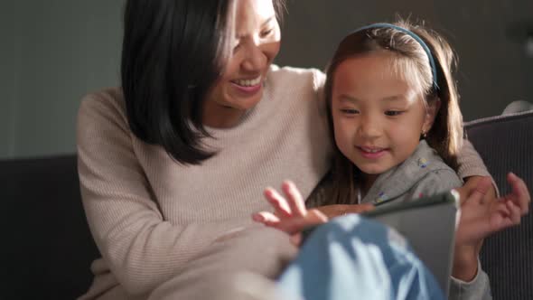 Happy mother and daughter looking at the tablet